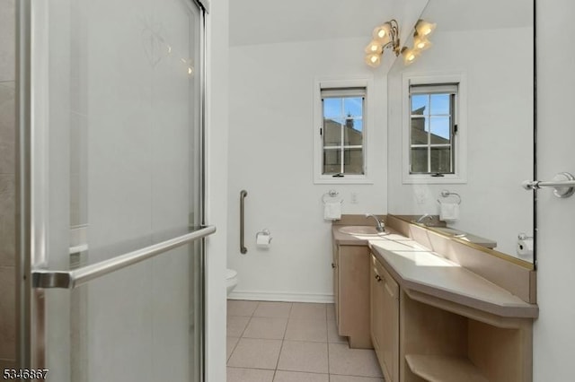 bathroom featuring baseboards, toilet, vanity, a stall shower, and tile patterned flooring