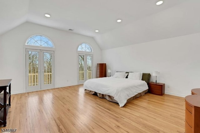 bedroom with vaulted ceiling, light wood-type flooring, and access to outside