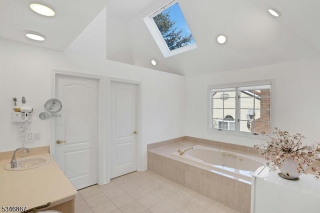 full bath with vaulted ceiling with skylight, tile patterned floors, recessed lighting, vanity, and a garden tub
