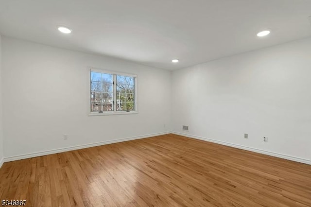 empty room with baseboards, visible vents, light wood-style floors, and recessed lighting