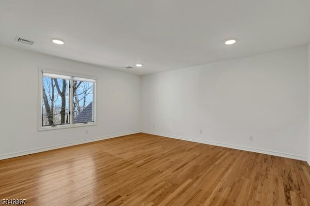 empty room featuring recessed lighting, baseboards, light wood finished floors, and visible vents