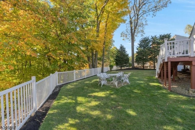 view of yard featuring a fenced backyard, stairway, and a wooden deck