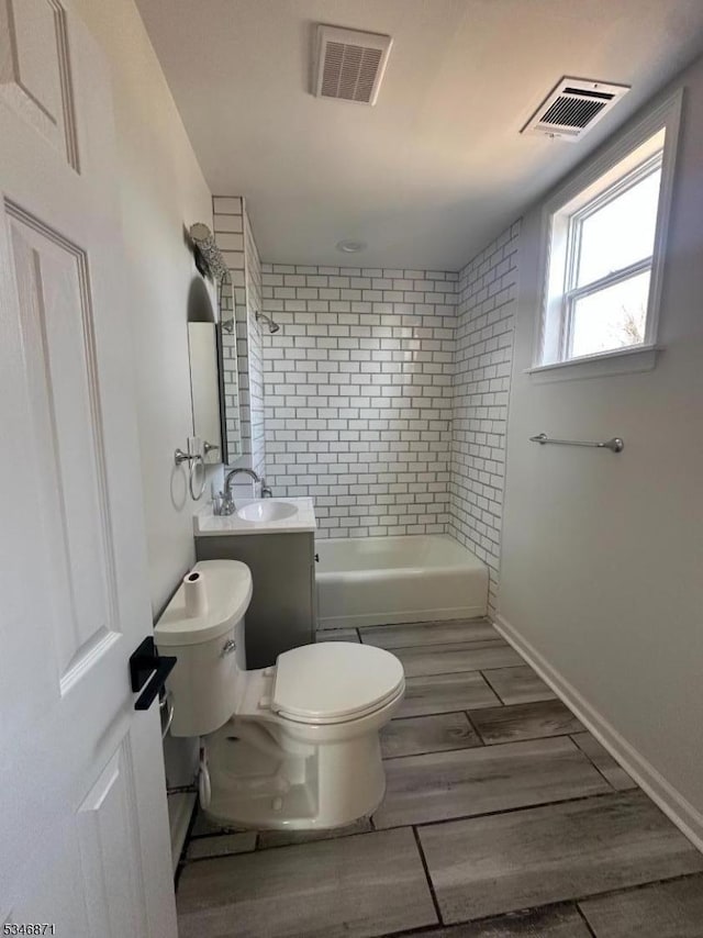 full bath with bathtub / shower combination, visible vents, toilet, and a sink