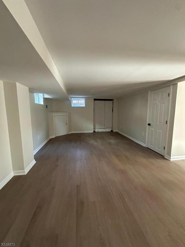 basement featuring baseboards and wood finished floors