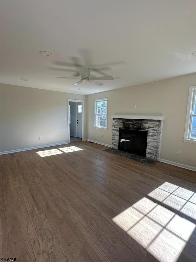 unfurnished living room with baseboards, wood finished floors, and a ceiling fan