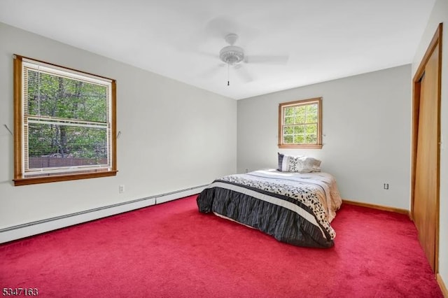 carpeted bedroom featuring a closet, baseboards, a ceiling fan, and a baseboard heating unit