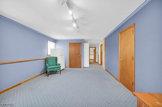 sitting room with baseboards, ornamental molding, light carpet, and rail lighting