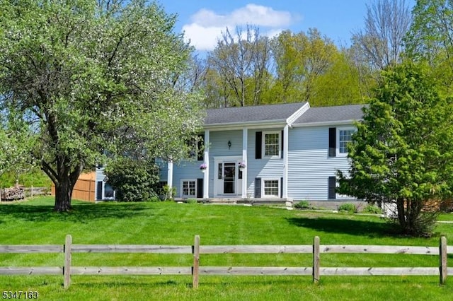split foyer home featuring fence and a front yard