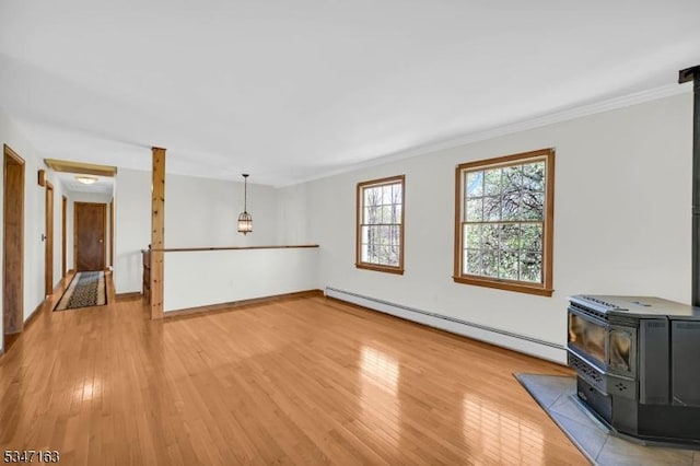 unfurnished living room with crown molding, a baseboard radiator, light wood finished floors, and a wood stove