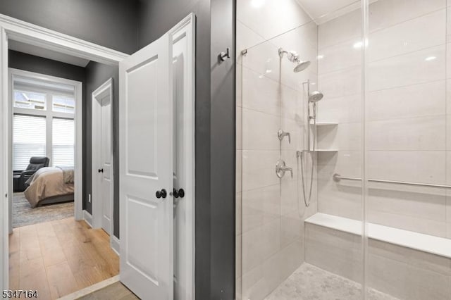 full bath with a shower stall and wood finished floors