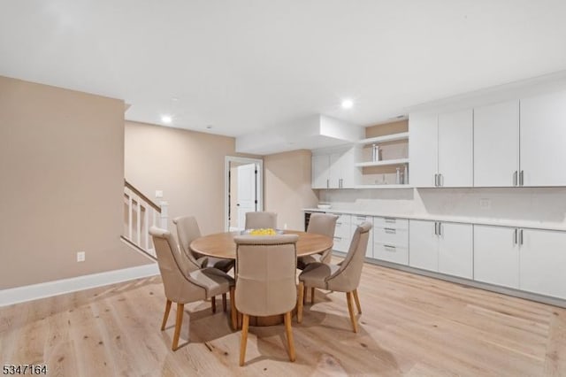 dining room with light wood-type flooring, recessed lighting, stairs, and baseboards