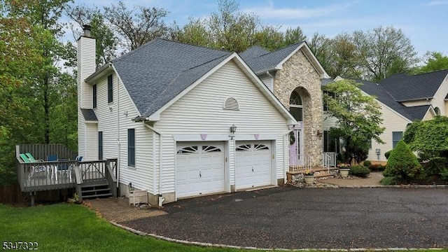 19 Trails End Ct, Westfield Town, NJ 07090 - view of front of house with a chimney, asphalt driveway, a deck, roof with shingles, and an attached garage