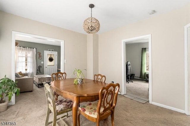 dining area featuring a notable chandelier and light carpet
