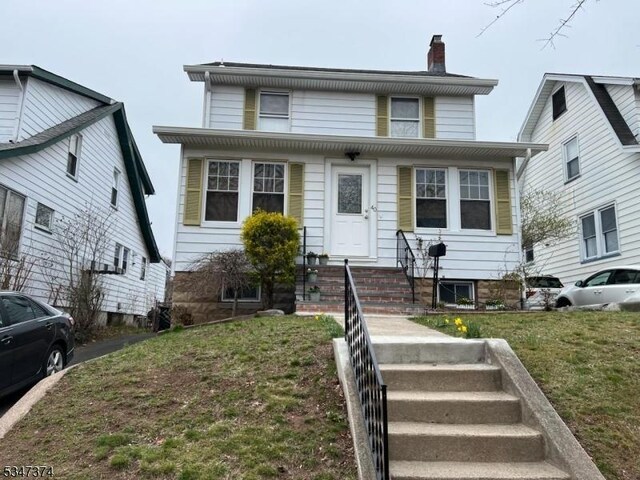 view of front facade featuring a chimney and a front yard