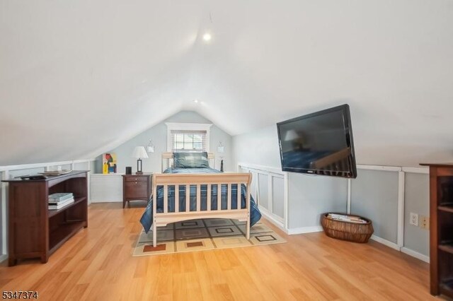 bedroom with lofted ceiling and wood finished floors