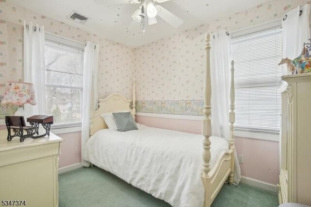 bedroom featuring visible vents, wallpapered walls, and light colored carpet