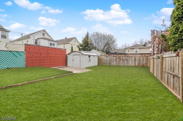 view of yard featuring a fenced backyard, an outbuilding, and a shed
