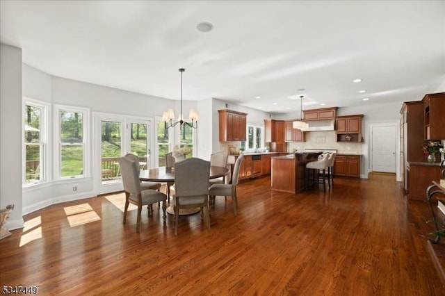 dining area featuring dark wood-type flooring, recessed lighting, baseboards, and a notable chandelier