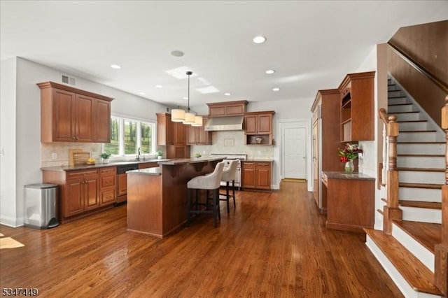 kitchen featuring open shelves, dishwashing machine, dark wood-style floors, a center island, and under cabinet range hood