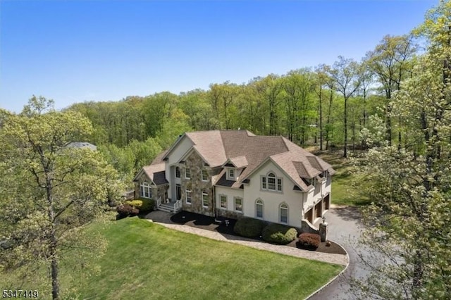 bird's eye view with a wooded view
