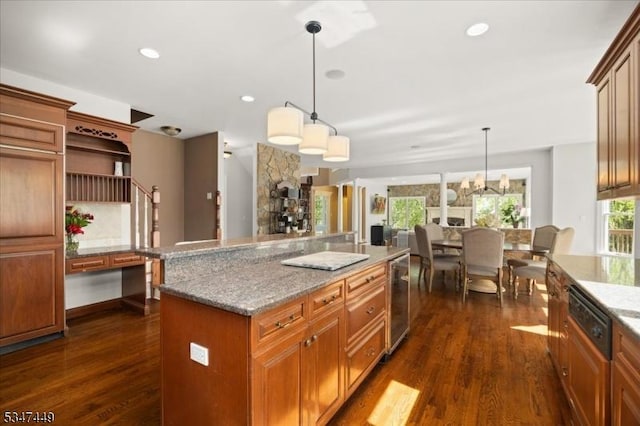 kitchen with light stone countertops, beverage cooler, a center island, decorative light fixtures, and dark wood-style floors