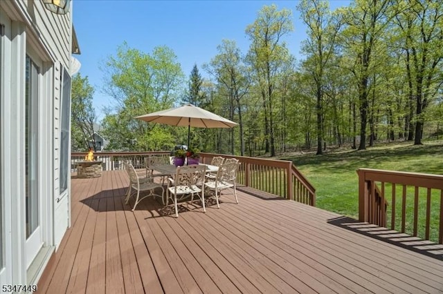 wooden terrace with a lawn and outdoor dining space