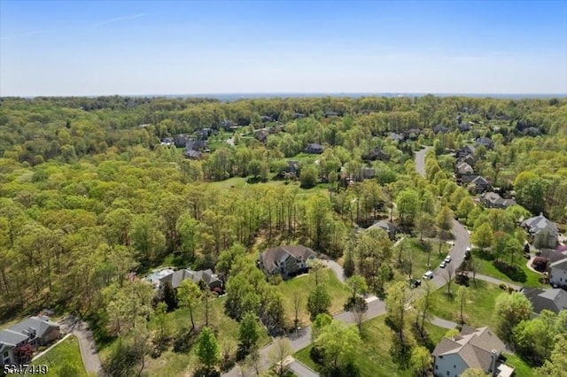 drone / aerial view featuring a wooded view