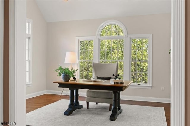 home office with baseboards, vaulted ceiling, dark wood-style floors, and a healthy amount of sunlight