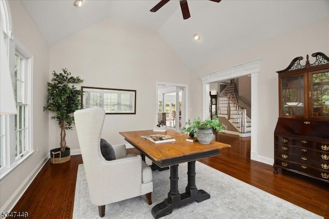 office area with baseboards, ceiling fan, wood finished floors, and high vaulted ceiling