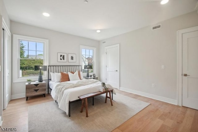 bedroom featuring recessed lighting, visible vents, light wood-style flooring, and baseboards