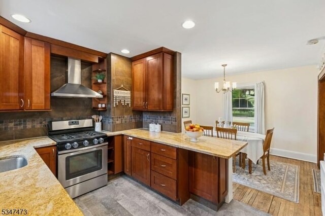 577-9 Greenbrook Rd, North Plainfield Boro, NJ 07063 - kitchen with stainless steel gas stove, wall chimney range hood, a chandelier, tasteful backsplash, and a peninsula