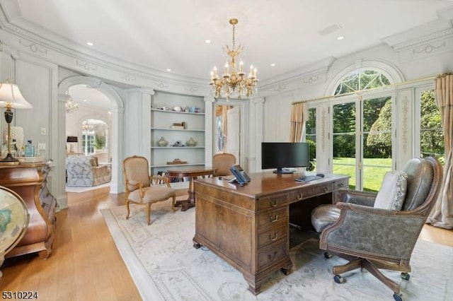 office area with arched walkways, an inviting chandelier, crown molding, and a healthy amount of sunlight