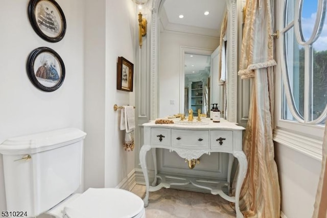 bathroom featuring toilet, crown molding, and vanity