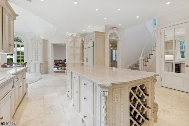 kitchen featuring recessed lighting, built in fridge, a large island, and light stone counters