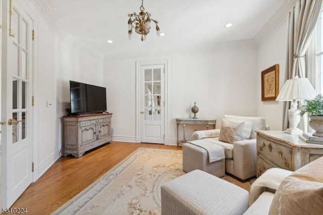 living area with light wood-style floors, an inviting chandelier, ornamental molding, and recessed lighting
