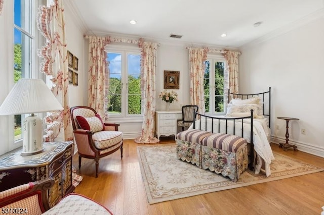 bedroom with visible vents, ornamental molding, and wood finished floors