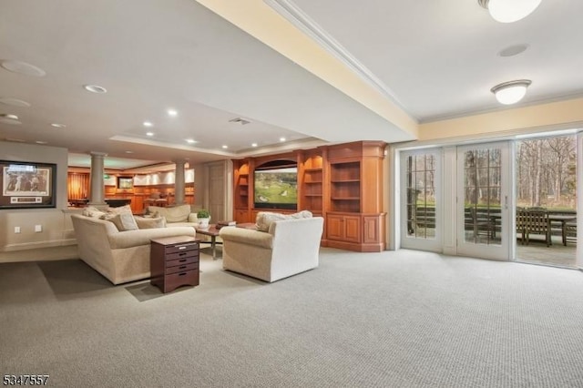living area with crown molding, ornate columns, light carpet, a raised ceiling, and recessed lighting