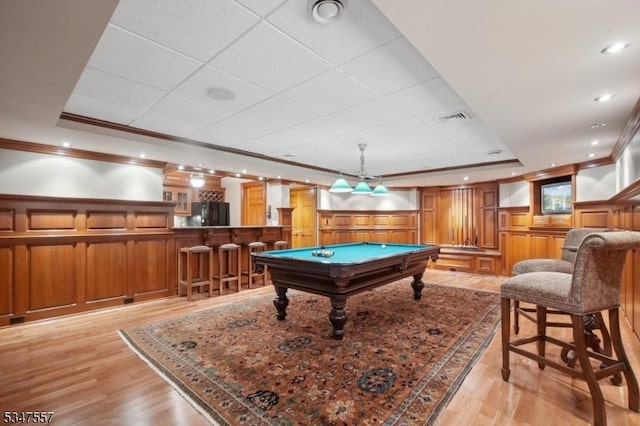 playroom with a tray ceiling, bar area, visible vents, and crown molding