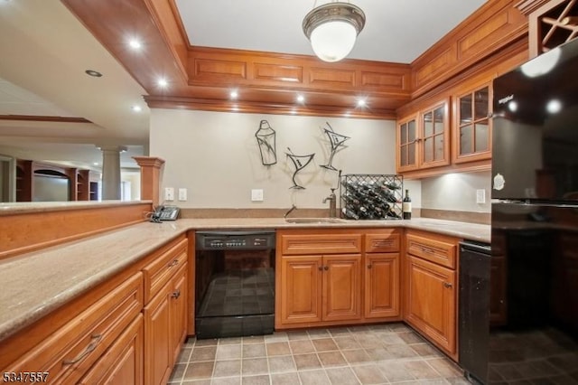 kitchen with light countertops, brown cabinetry, a sink, and black appliances