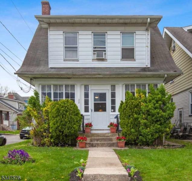 view of front of house with a front lawn, a chimney, and entry steps