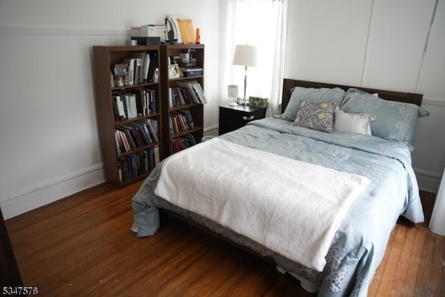 bedroom with wood finished floors and baseboards