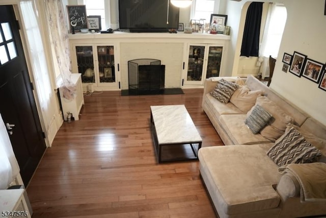 living area with hardwood / wood-style flooring and a fireplace