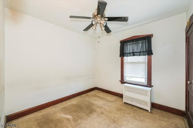 spare room featuring radiator, baseboards, and a ceiling fan