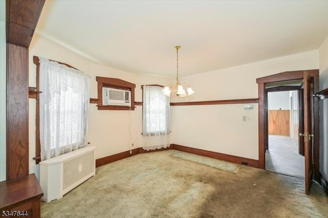 carpeted empty room featuring plenty of natural light, a chandelier, baseboards, and radiator heating unit