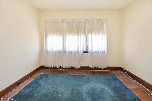empty room with plenty of natural light and baseboards