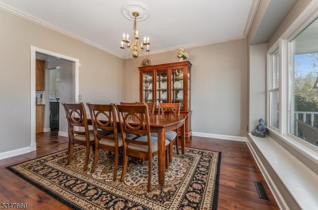 dining area featuring dark wood-style flooring, crown molding, a chandelier, and visible vents