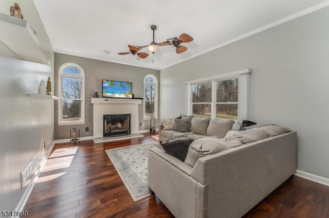 living room featuring ceiling fan, visible vents, ornamental molding, and a healthy amount of sunlight