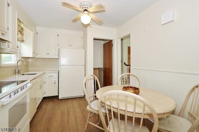 2379 Bryant Ave, Scotch Plains Twp, NJ 07076 - kitchen with white appliances, wood finished floors, white cabinetry, light countertops, and a wainscoted wall