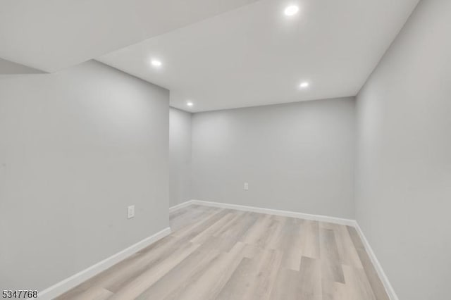 finished below grade area featuring light wood finished floors, baseboards, and recessed lighting