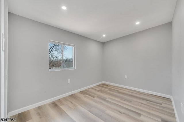 spare room featuring baseboards, light wood-type flooring, and recessed lighting